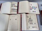 plusieurs livres ouverts, sur lesquels sont apposés des timbres, posés sur une table