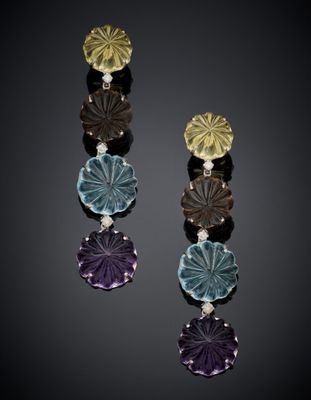 a close up of a pair of earrings on a black surface