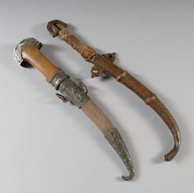 une paire d'épées anciennes en bois et en métal posées sur une surface blanche