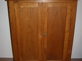 a wooden cabinet with a mirror on top of it