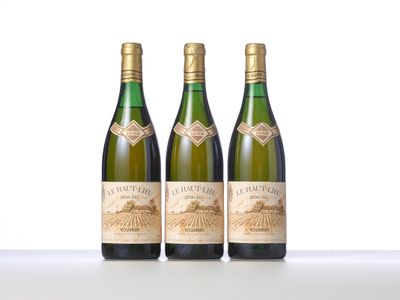 trois bouteilles de vin posées sur une table blanche