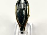 an image of a black and gold ring on a clear stand