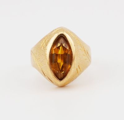 a close up of a gold ring with a faceted citrine stone