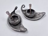 two metal objects that are sitting on a white surface