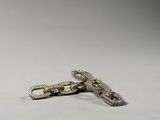 silver chain with a cross on it laying on a white surface