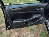 the door of a car is open on the grass in front of a house