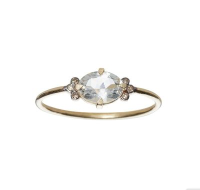 un gros plan d'une bague en or sertie d'une topaze blanche