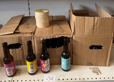Plusieurs bouteilles de bière sont posées sur une étagère dans un magasin.