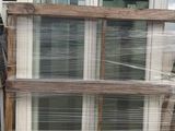 a stack of windows sitting on a pallet in front of a building