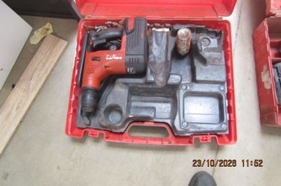 une boîte à outils rouge contenant un marteau et d'autres outils