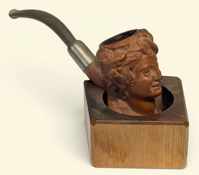 une statue représentant un homme tenant une pipe dans un support en bois