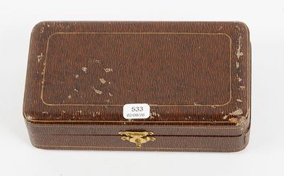 an old wooden box with a tag on it sitting on a white surface