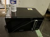 a bottle of water sitting on top of a microwave