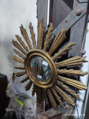 a gold sunburst sitting on top of a wooden table