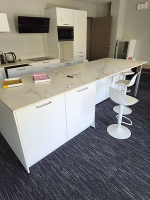 an image of a kitchen with a marble counter top and bar stools
