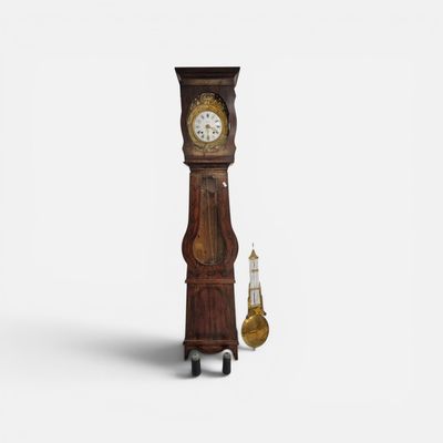 une grande horloge en bois avec un pendule sur le côté