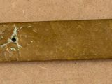 a small gold object on a wooden surface