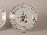 pair of plates with flowers and birds painted on them sitting on a table