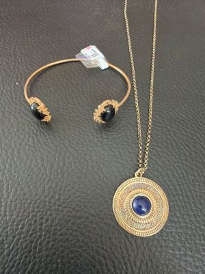 a gold necklace and bracelet set with a blue stone