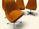 quatre chaises orange disposées les unes à côté des autres sur une surface blanche