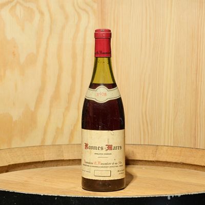 a bottle of wine sitting on top of a barrel