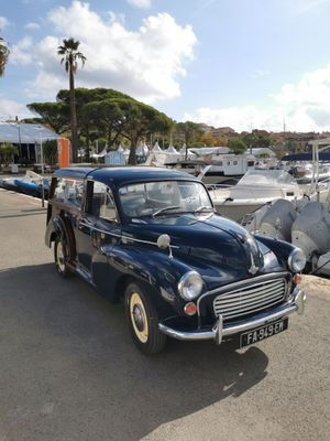 une voiture bleue garée à côté de quelques bateaux