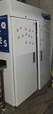 un réfrigérateur blanc au milieu d'une pièce, à côté d'une borne d'incendie