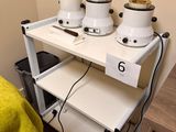 a white shelf with three pots on top of it