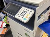 a multi - function printer sitting on top of a pile of books