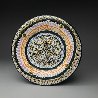 a colorful plate with a design on it on a gray surface