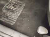 a dirty car floor with a dirty floor mat