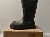 a pair of black rain boots sitting on top of a box