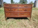 une commode en bois posée au milieu d'un champ recouvert d'herbe
