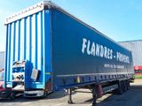 a blue semi trailer parked in front of a building