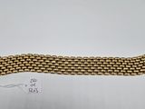 une image d'un bracelet en or sur une surface blanche