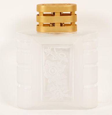 l'image d'un flacon de parfum posé sur une surface blanche