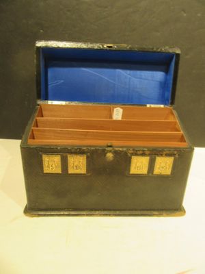 a small black box with a blue lid on a white table
