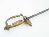 a gold colored sword with a handle on a white surface