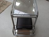 a glass table with a shelf on it in the middle of a room