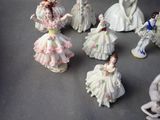 many figurines of women dressed in white dresses on a table