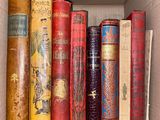 many books in a box that are sitting on a shelf