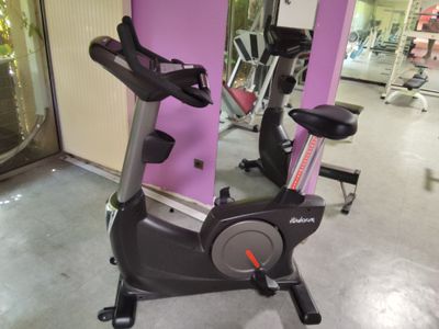 un vélo d'appartement dans une salle de sport aux murs roses