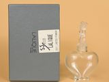 l'image d'un flacon de parfum posé à côté d'une boîte