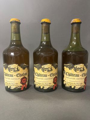 trois bouteilles de vin sont alignées sur une table