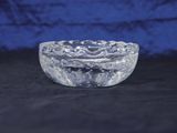 clear glass bowl on a black surface with a blue background