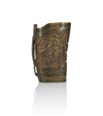 an old bronze pitcher with a dragon design on the handle