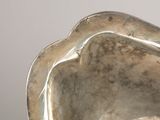a silver vase that is sitting on a table