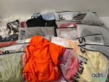 de nombreux sacs de vêtements et des vêtements éparpillés par terre