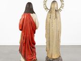 two statues of jesus and a woman in a red robe