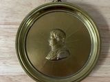 une plaque en laiton ancien sur laquelle figure le portrait d'un homme